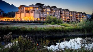 A multi-story hotel with balconies, a restaurant, and a view of mountains. - Executive Suites Hotel & Resort, Squamish (Squamish)