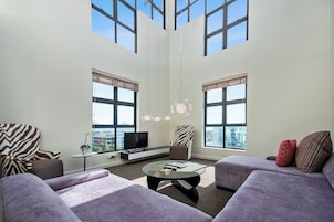 A modern living room with a sofa, armchair, and a coffee table.