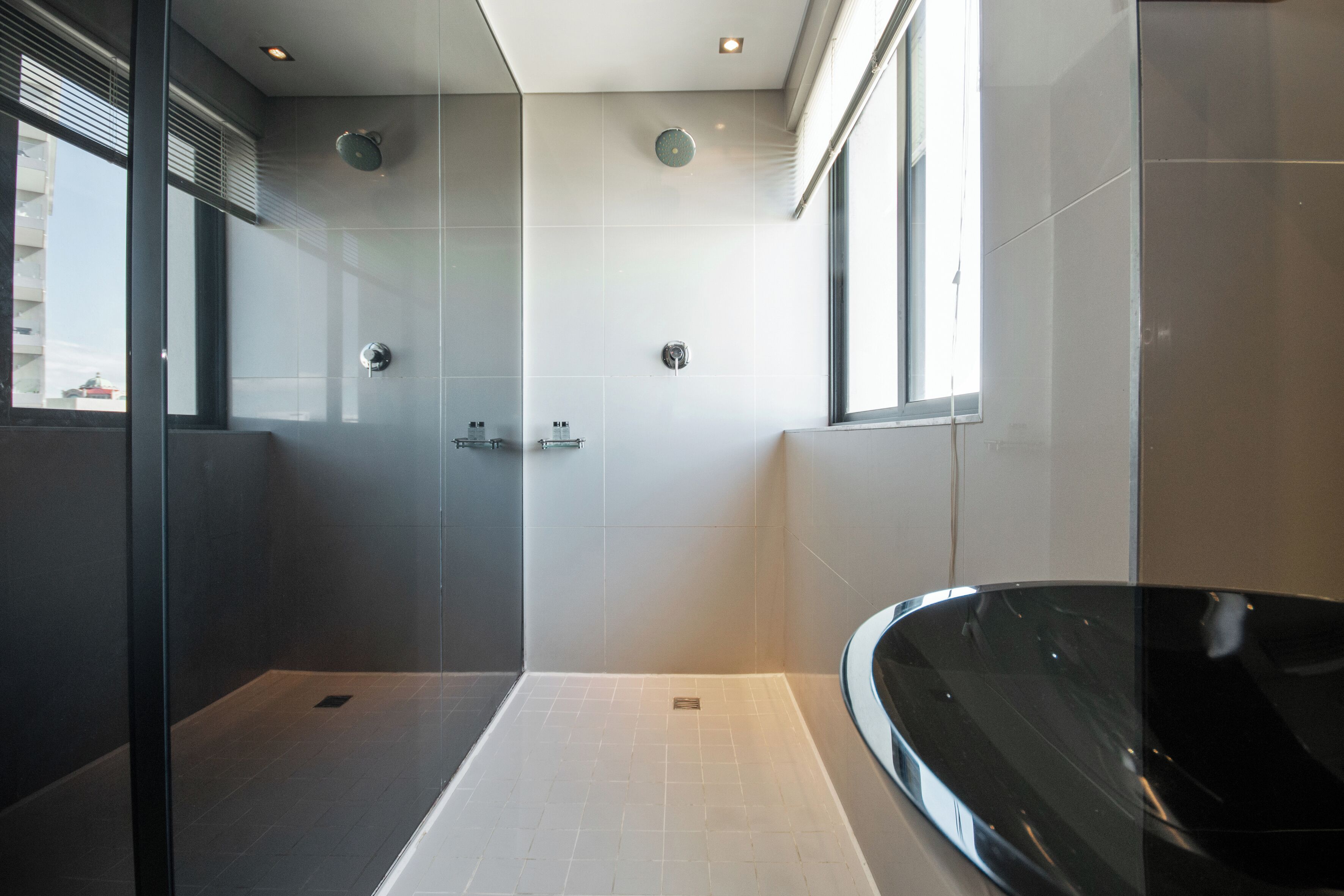 Un baño moderno con ducha de vidrio, una bañera independiente y un amplio ventanal que proporciona luz natural.