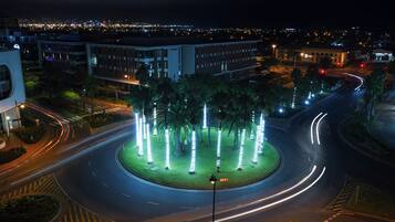 Una glorieta con palmeras y farolas iluminadas.