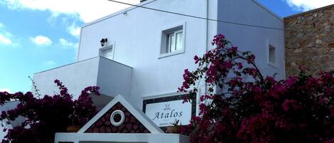 Un edificio blanco con un cartel que dice 'Atalos Hotel'.