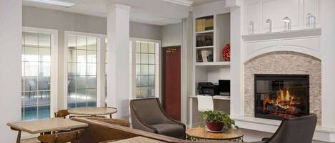 A modern interior with a fireplace, seating area, and a bookshelf.