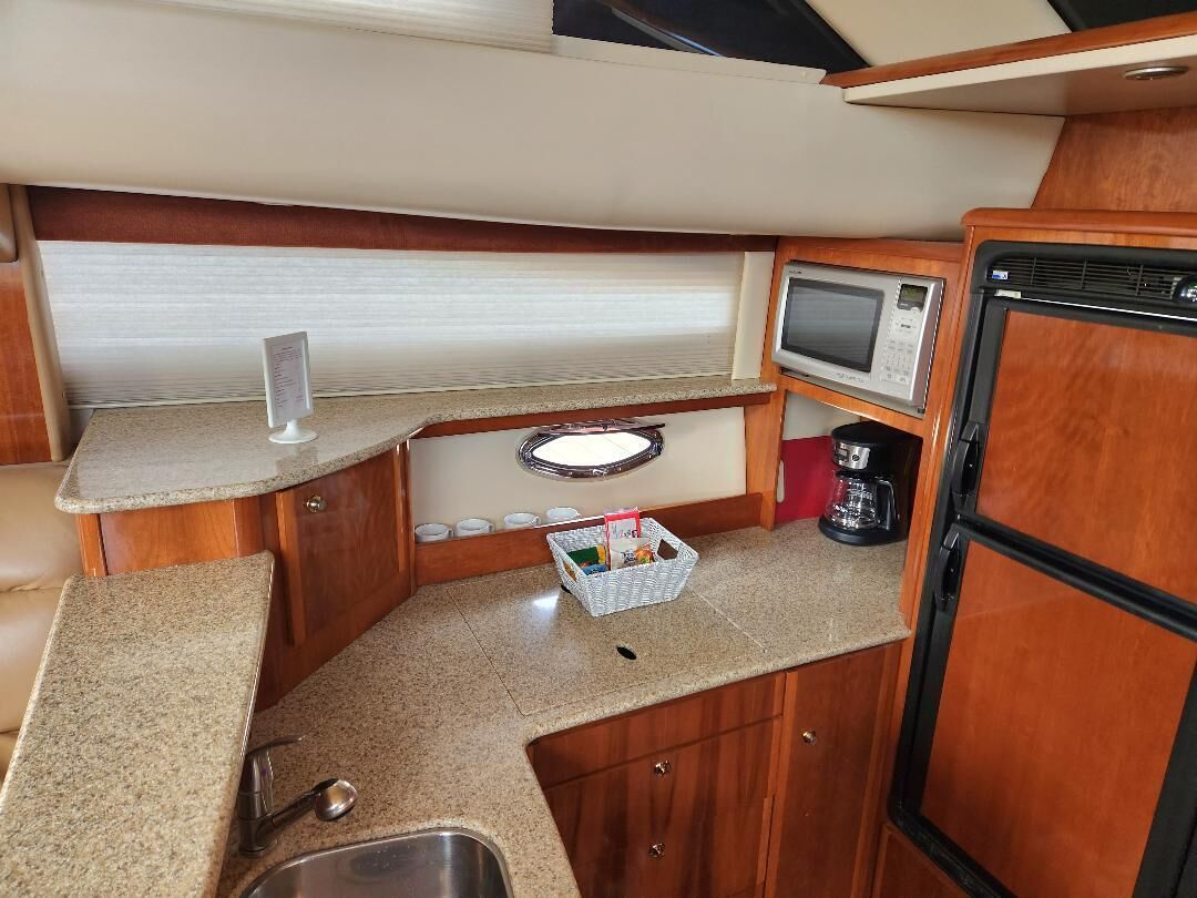 A compact kitchenette with a microwave, coffee maker, and a small sink.
