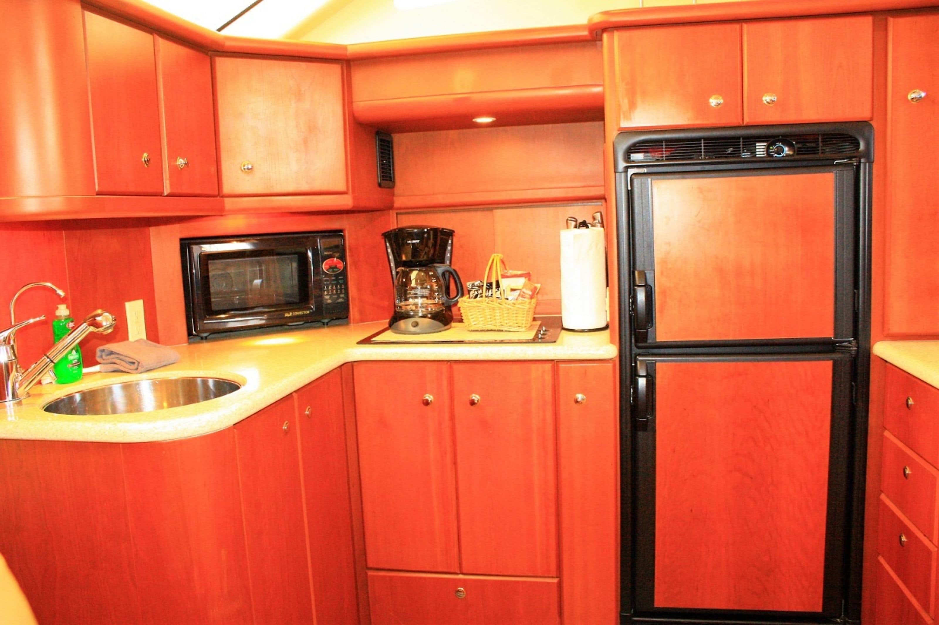 A compact kitchen with a microwave, coffee maker, and refrigerator.