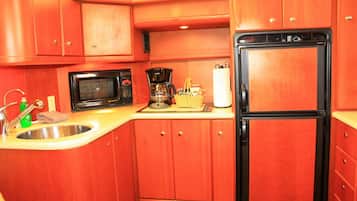 A compact kitchen with a microwave, coffee maker, and refrigerator.