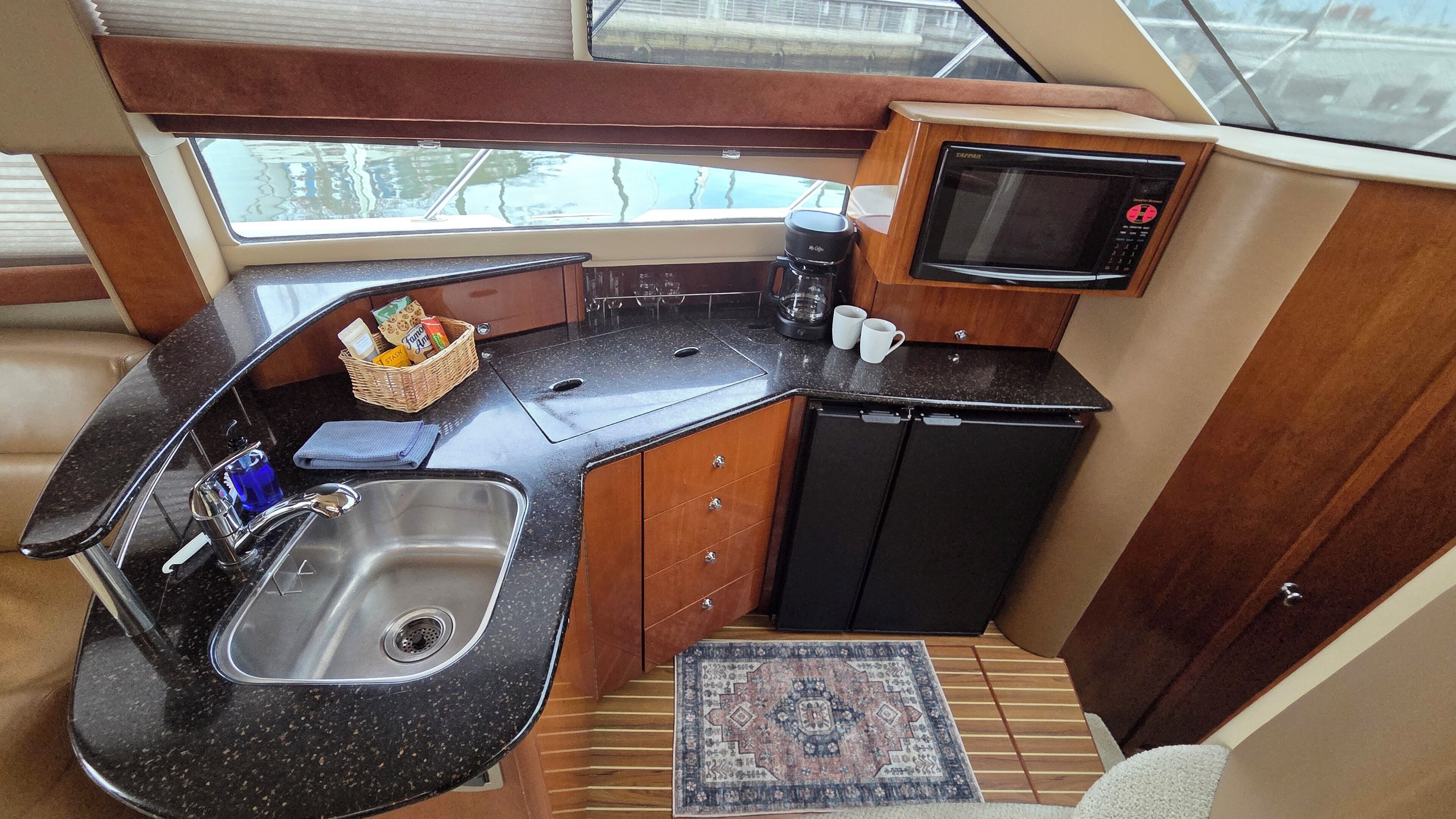 A compact kitchen with a sink, microwave, and small refrigerator.