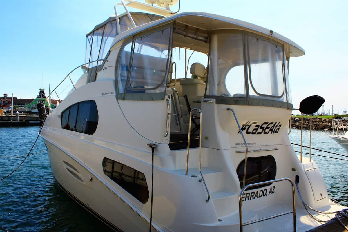 A white yacht named #CaseAla with a cabin, windows, and a nameplate reading "ERRADO, AZ".