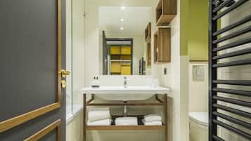 A modern bathroom with a large mirror, white sink, and wooden shelves.