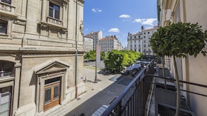 Vista de la calle con edificios, un árbol y un paso de peatones.