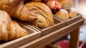 A wooden display case with various pastries, including croissants and other baked goods.