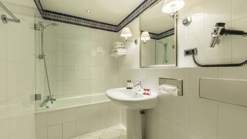A modern bathroom with a glass-enclosed shower, a standalone bathtub, and a pedestal sink.