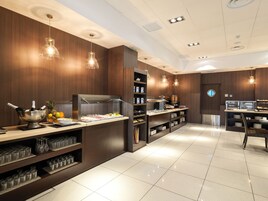 Un área de cocina moderna con un montaje tipo buffet, que incluye una variedad de alimentos y un refrigerador de vinos.