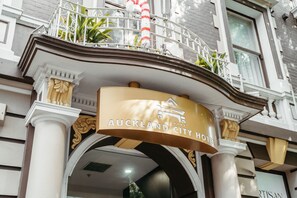 The Auckland City Hotel entrance with a sign above the doorway, columns, and a balcony with railings and plants. - Auckland City Hotel (Auckland)