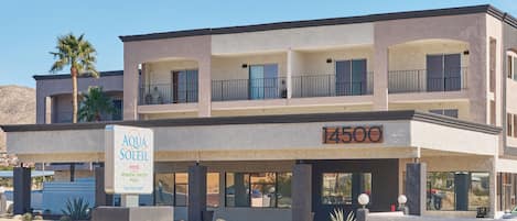 A multi-story hotel with a sign for Aqua Soleil Hotel and Mineral Water Pool.