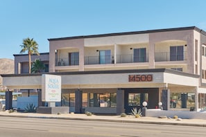 A multi-story hotel with a sign for Aqua Soleil Hotel and Mineral Water Pool.