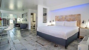 Un dormitorio moderno con una cama grande, mesitas de noche, un escritorio y una silla.