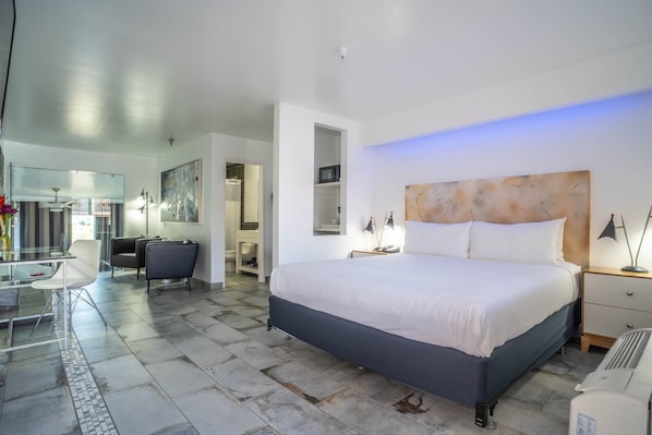Une chambre moderne avec un grand lit, des tables de chevet, un bureau et une chaise.