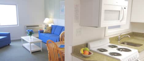 A compact kitchen with a stove, microwave, and sink. There's a dining area with a blue sofa and a small table.
