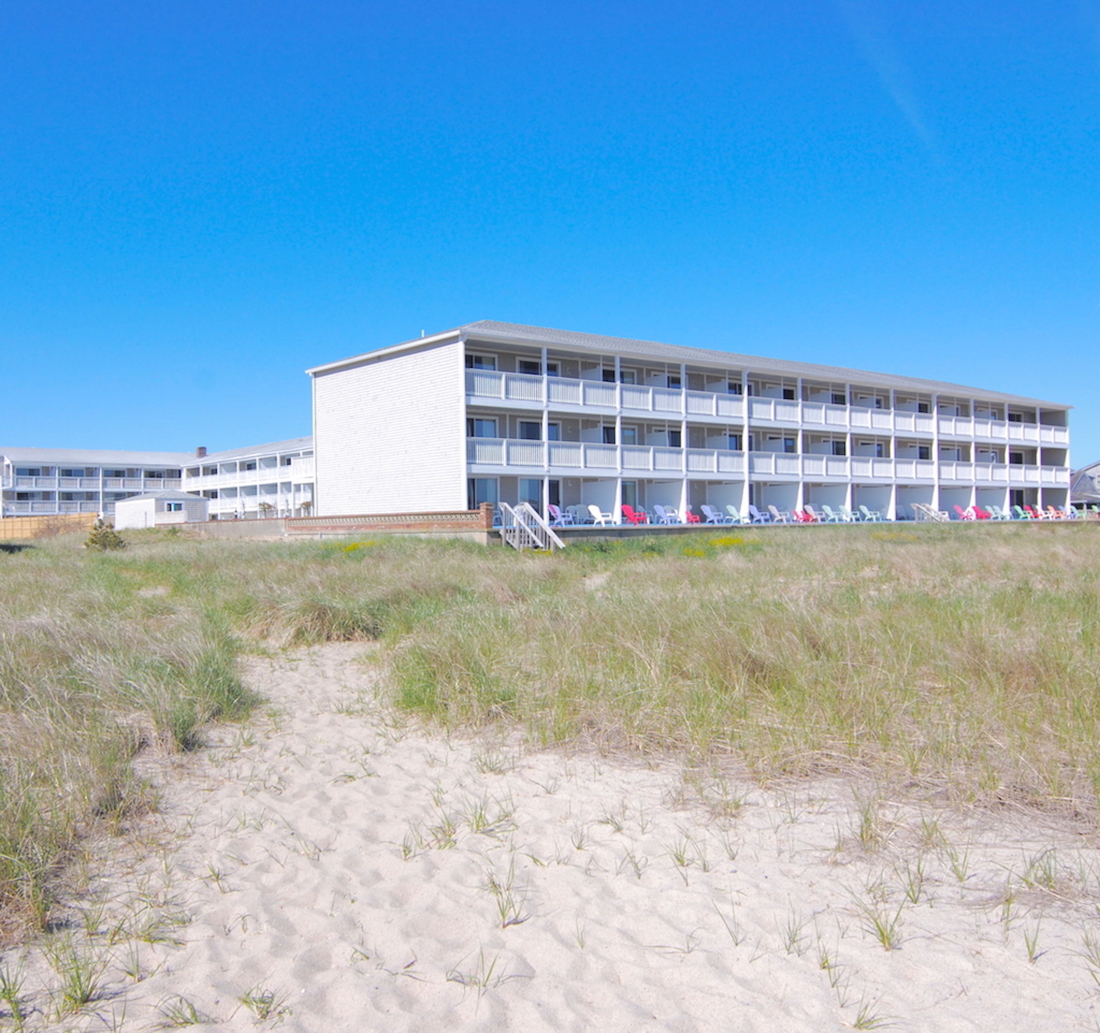 A multi-story hotel with a flat roof and a balcony on each floor.