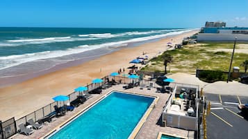 Een buitenzwembad, parasols voor strand/zwembad