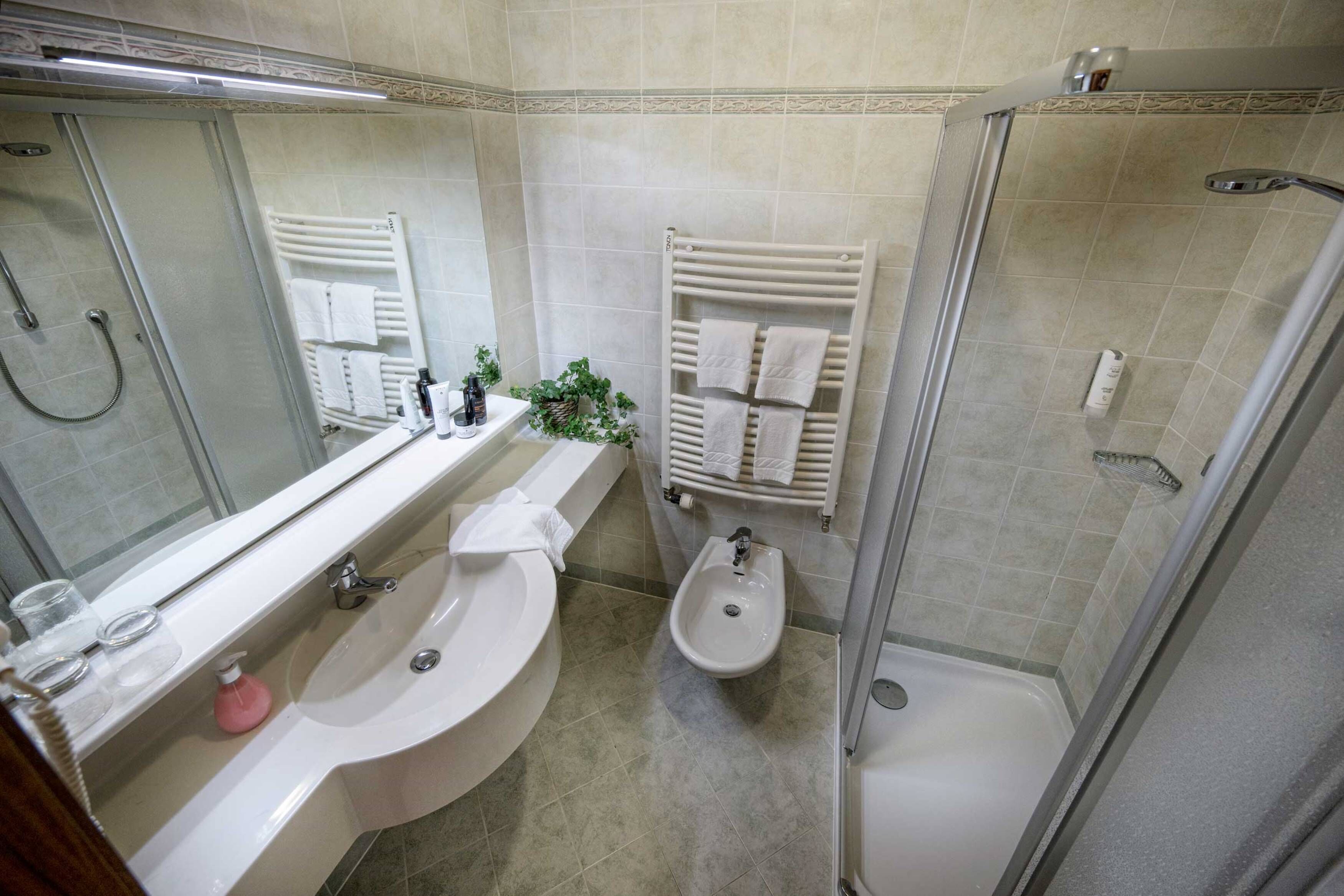 Une salle de bain moderne équipée d’une baignoire, d’un lavabo, d’un bidet et d’une douche.