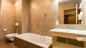 A modern bathroom with a bathtub, toilet, and sink.