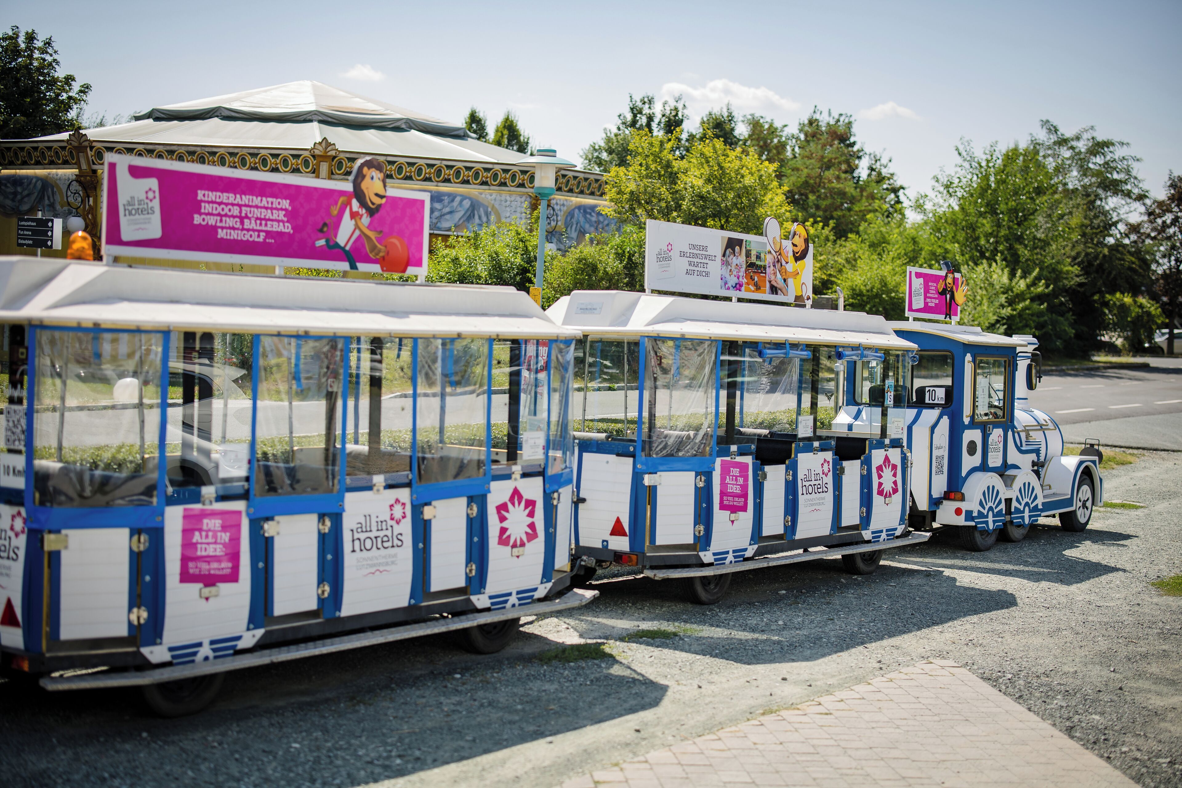 A row of blue and white tour buses with advertisements for hotels and activities.