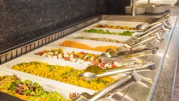 A buffet with various food options and serving utensils.