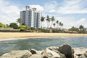 A beachfront hotel with a large building, palm trees, and a sandy beach. - Global Towers Hotel & Apartments (Colombo)