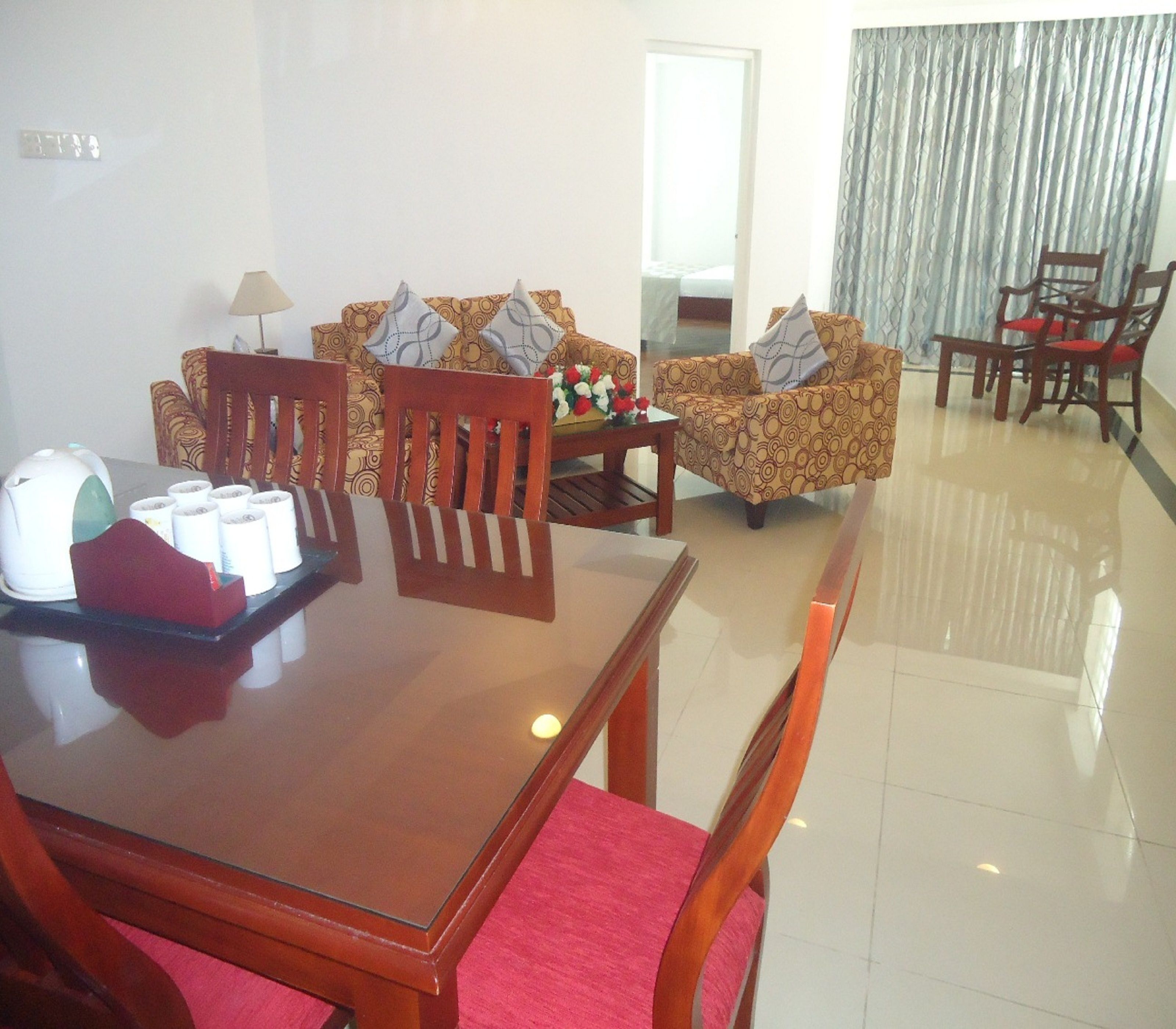 A dining area with a wooden table, chairs, and a sofa set.