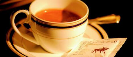 Una taza de té con un platito y sobres de té.