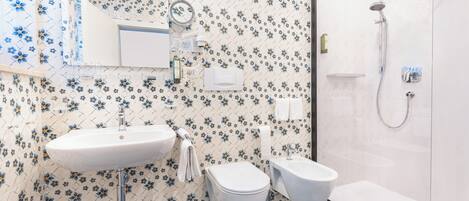 A bathroom with a sink, toilet, and shower.