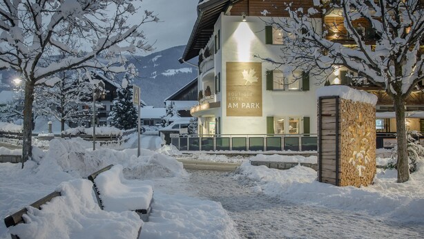 A multi-story hotel with a sign reading "BOUTIQUE AM PARK." - Boutique Hotel Am Park (Valdaora)