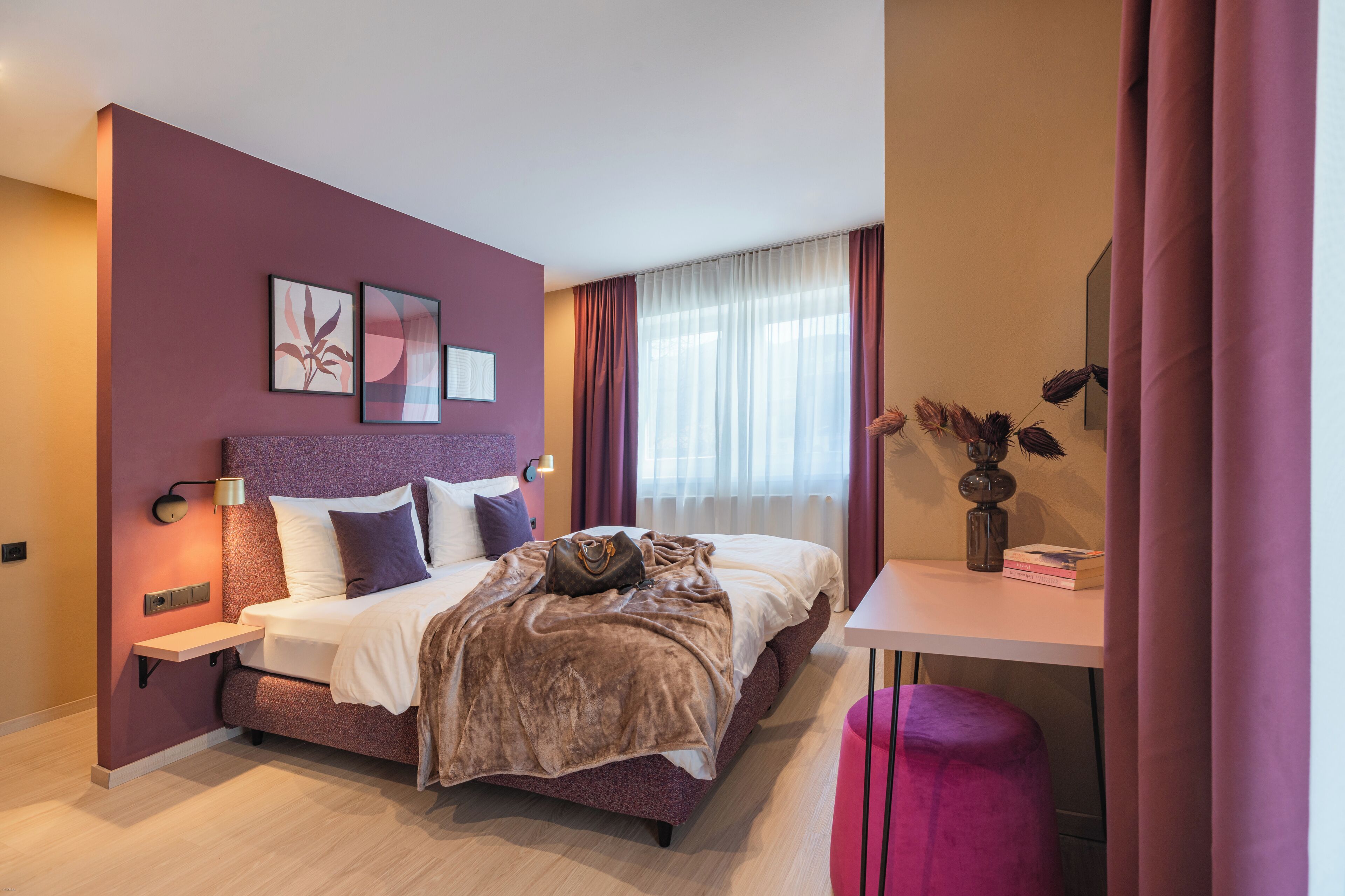 Un dormitorio moderno con una cama grande, mesitas de noche, un escritorio y una silla.