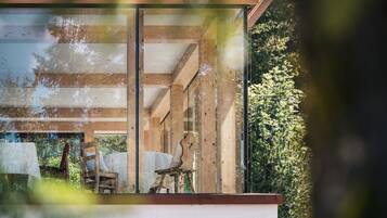 Un interno moderno con soffitto in legno e ampie finestre in vetro.