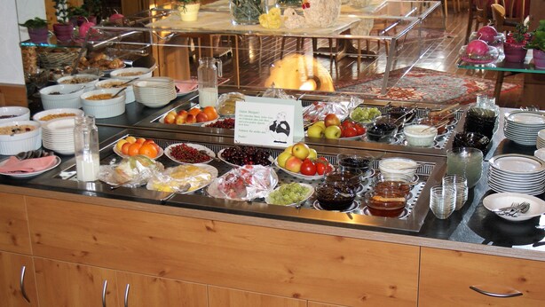 A buffet with various food items and a sign with a cartoon character. - Hotel Altenberg (Baden-Baden)