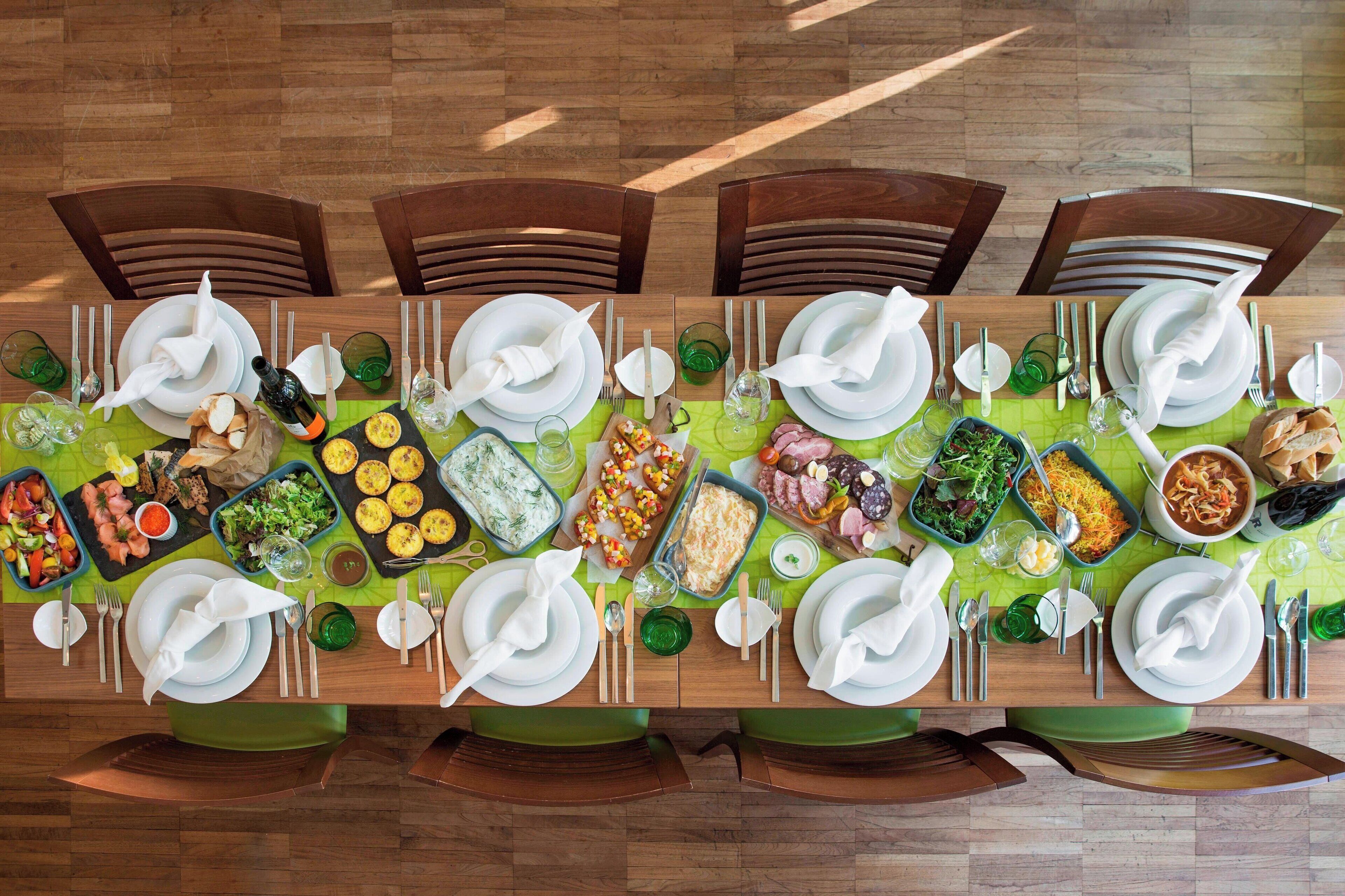 Mesa de jantar posta para refeição, com vários pratos e talheres.