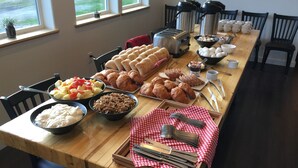 A breakfast buffet with various food items, including fruits, pastries, and beverages. - Alaska Glacier Lodge (Palmer)