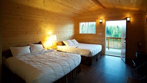 A cabin with two beds, wooden walls, a balcony, and a door leading outside. - Alaska Glacier Lodge (Palmer)