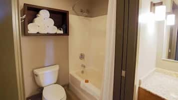 A bathroom with a toilet, a shower, a sink, and a towel rack.