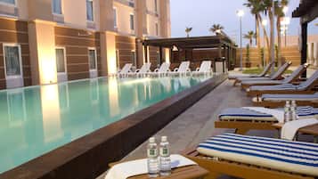 Piscine extérieure en saison, chaises longues