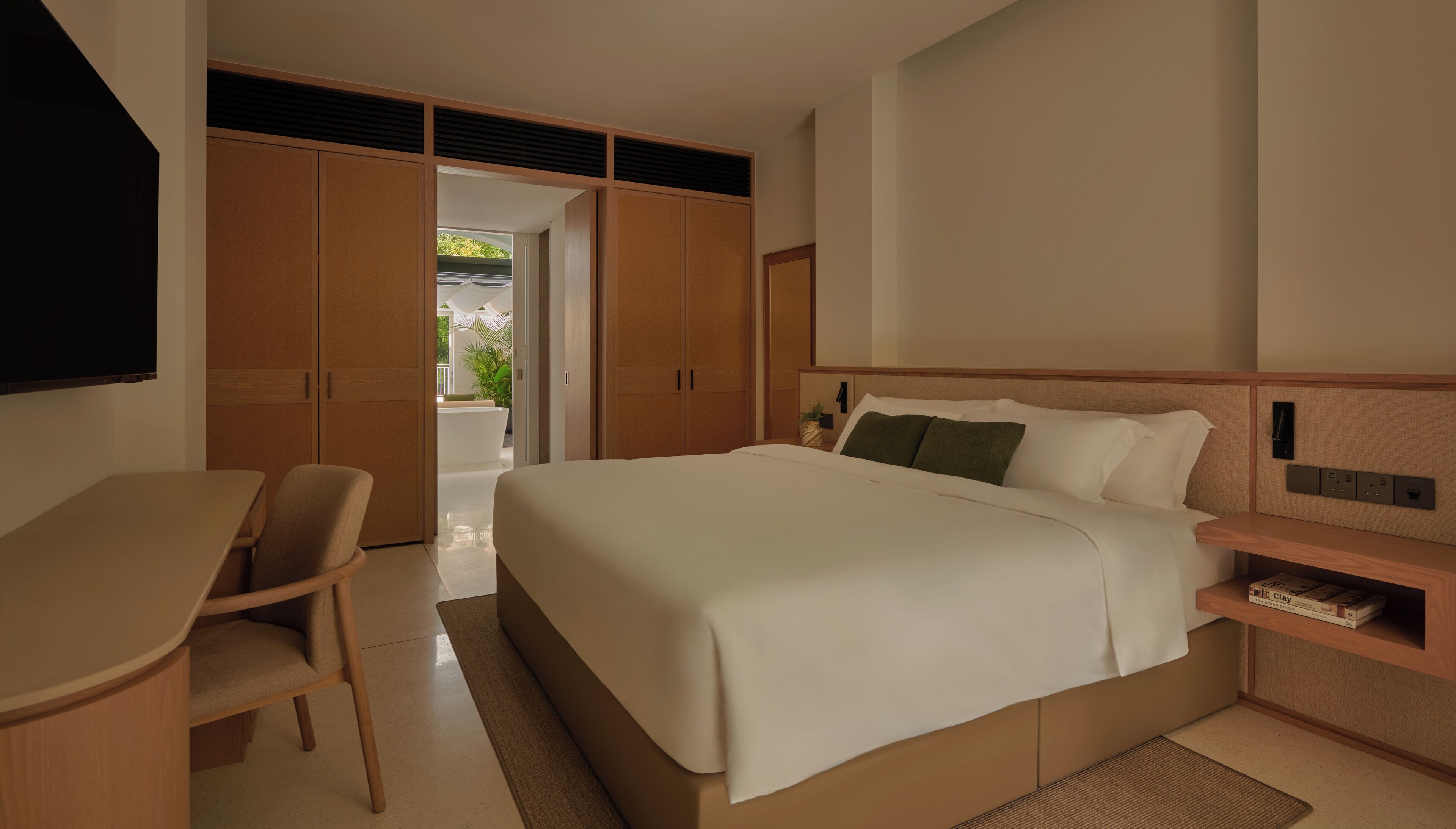 Une chambre d’hôtel avec un lit, un bureau et une armoire.