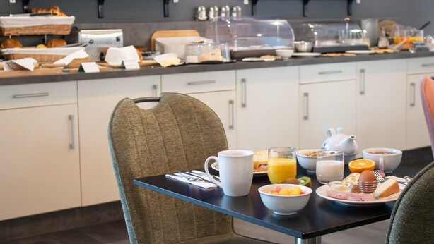 A breakfast buffet with various food items and beverages on a table.