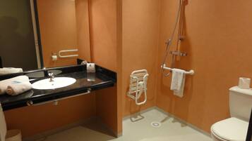 A bathroom with a black sink, white toilet, and a shower.