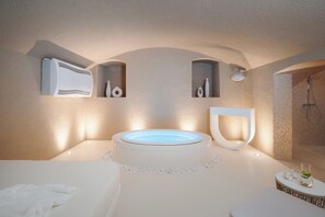 Un spa moderno con una bañera de hidromasaje central, aire acondicionado de pared y zona de ducha.