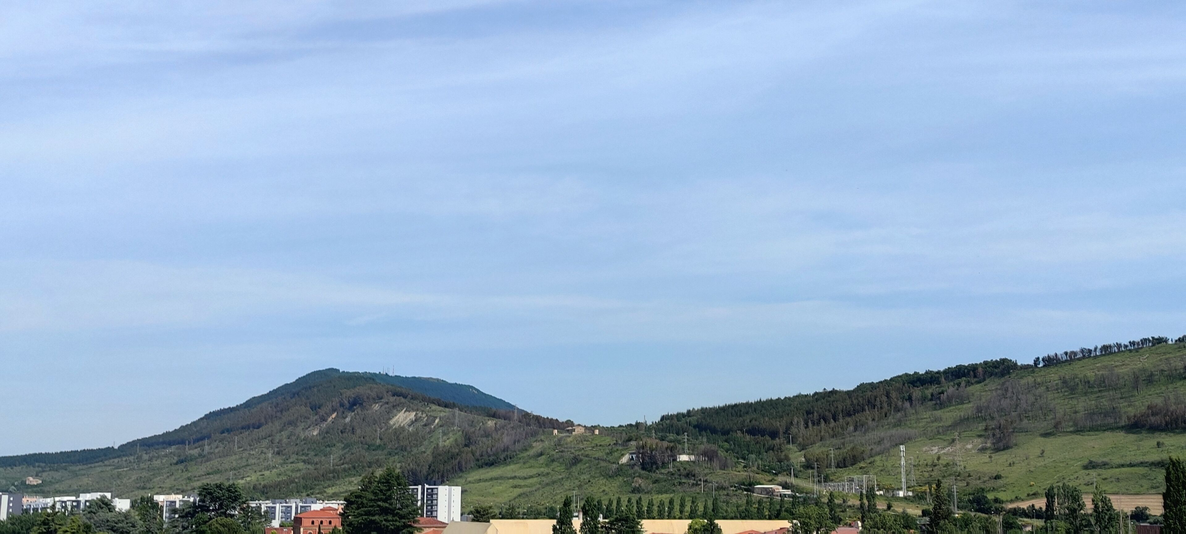Paisaje montañoso con edificios en primer plano.