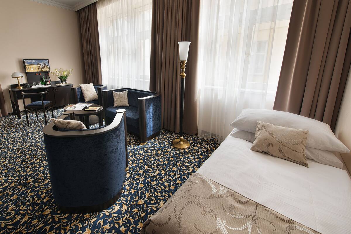 Una habitación de hotel con cama, sofá, escritorio y silla.