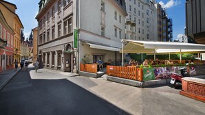 A street view with a hotel named "Hotel Esprit" and a restaurant with outdoor seating. - EA Hotel Royal Esprit (Prague)