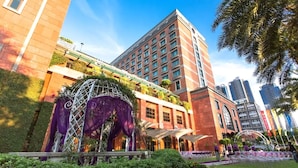 Un hotel con fachada de ladrillo rojo, un amplio atrio con techo de vidrio y vistas al horizonte de la ciudad.