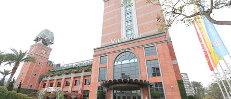 A large brick building with a clock tower and a sign that reads "Victoria."